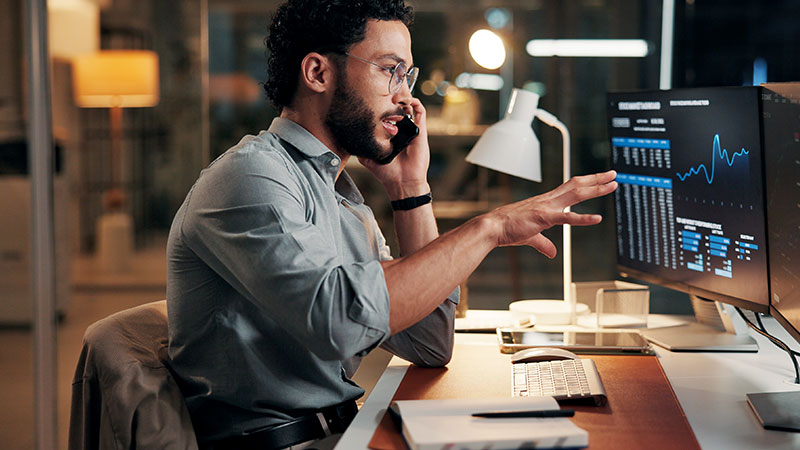 Homem observa uma interface de computador com uma tabela e um gráfico